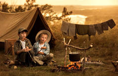 两个孩子坐在篝火旅行者身边 