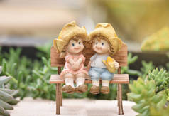 小情侣娃娃可爱坐在木凳上装饰的花