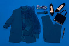 上衣、夹克、裤子、高跟鞋、腰带、包、腕表的顶视图，蓝色孤立