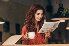 一杯咖啡的女人的画像在桌上用手提电脑在咖啡馆读报纸