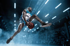 篮球运动员在大的专业竞技场比赛期间。篮球运动员打扣篮.