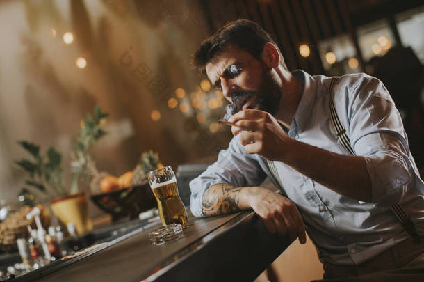 晚上在酒吧<strong>喝啤酒</strong>抽烟的男人