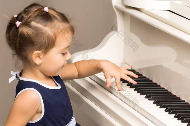 那女孩在白色的大钢琴旁.