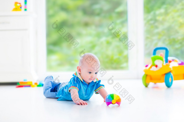 可爱的宝宝男孩<strong>玩耍</strong>着五颜六色的球、 玩具车