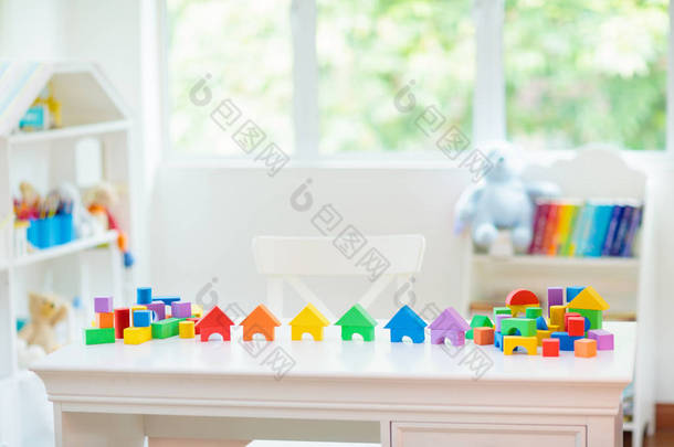 儿童卧室配有白色书桌和教育玩具块。五颜六色的方块玩具为幼儿。托儿所或日托所。男孩或女孩的<strong>幼儿园</strong>或学前班.