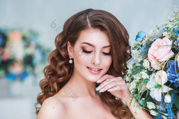 年轻貌美的新娘，婚礼化妆和发型室内。年轻的华丽新娘在工作室的特写肖像
