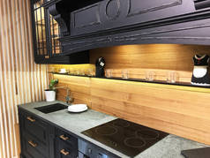 精美的定制厨房设计。 带有装饰和木墙的现代化厨房.