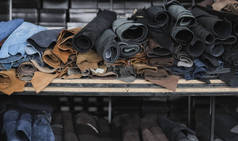 不同的皮革在一个卷。有色皮革的碎片。天然棕色和黑色和其他皮革的卷。生产箱包、鞋类、服装及配饰的原材料.