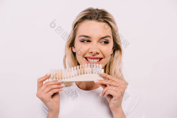 美丽的微笑的女人拿着牙齿调色板隔离在白色, 牙齿美白的概念