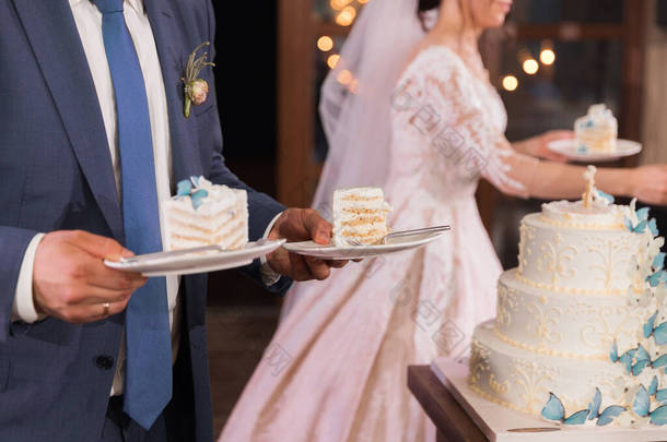 在新娘和新郎的手里切下一块<strong>结婚蛋糕</strong> 