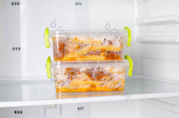 在冰箱里的一个容器里准备了冰冻的饭菜.冷冻食品在冰箱里.快速烹调概念