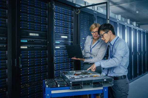 在现代数据中心:工程师和它专家与服务器机架,在<strong>推车</strong>设备上安装新硬件。专家对数据库进行维护和诊断.