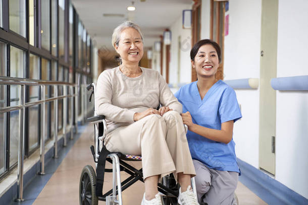 亚洲老妇人和她的护理者微笑着看着摄像机