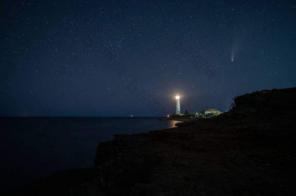 《人类发展报告》夜间在白色灯塔上方发现著名的新慧星的景观