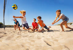 在沙滩排球比赛中与朋友们一起碰撞传球的快乐少年肖像