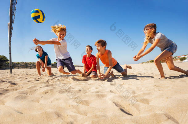 在沙滩排球比赛中与朋友们一起碰撞传球的快乐少年肖像