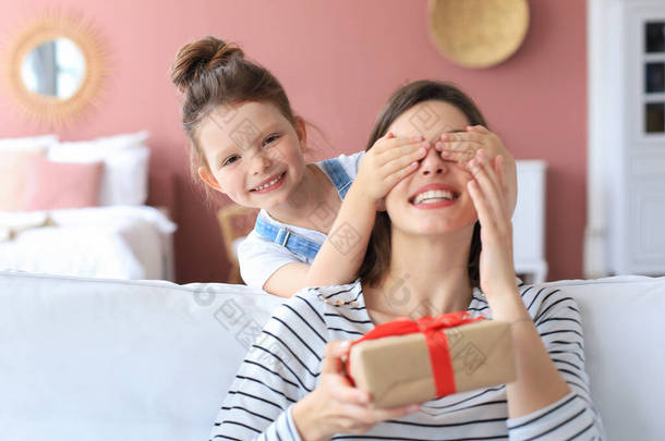 小女孩给兴奋的父母做生日礼物，笑着的小孩祝贺送给<strong>快乐</strong>的母亲礼品盒和闭着的母亲的眼睛