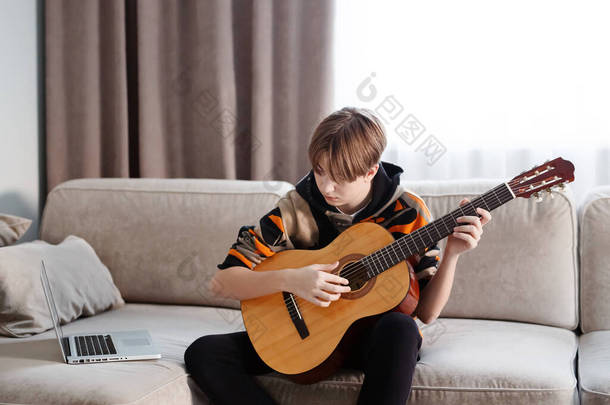 男孩在家里弹吉他，网上上课。高质量的<strong>录像</strong>