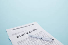 保险形式、保险健康索赔表和蓝色笔隔离的特写视图