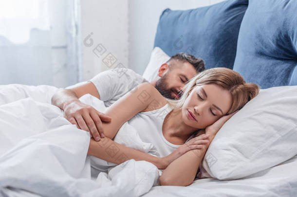 美丽的金发碧眼的女人睡在床上与男朋友在早上 