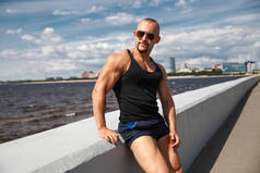 在俄罗斯圣彼得伯格尔芬兰湾堤岸上，一个阳光灿烂的夏日，一位运动健美的年轻男子.