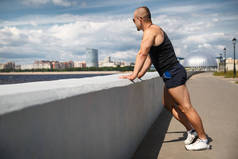 在俄罗斯圣彼得伯格尔芬兰湾堤岸上，一个阳光灿烂的夏日，一位运动健美的年轻男子.