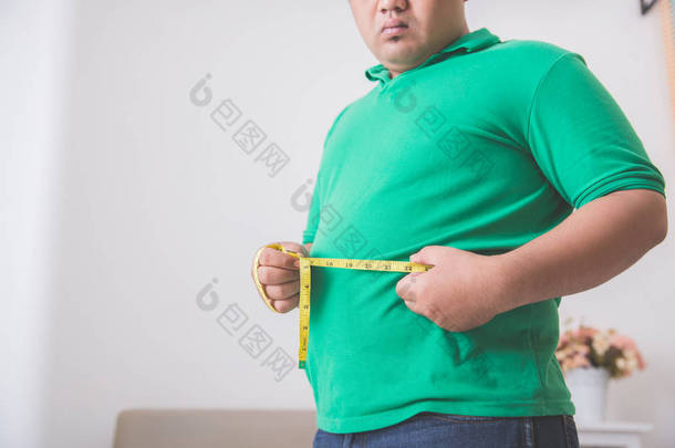 超重的人测量他的肚子在家里