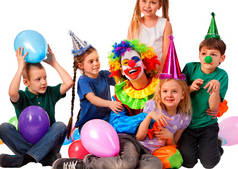 玩耍的孩子们的生日小丑。戴方帽子住气球的孩子 .