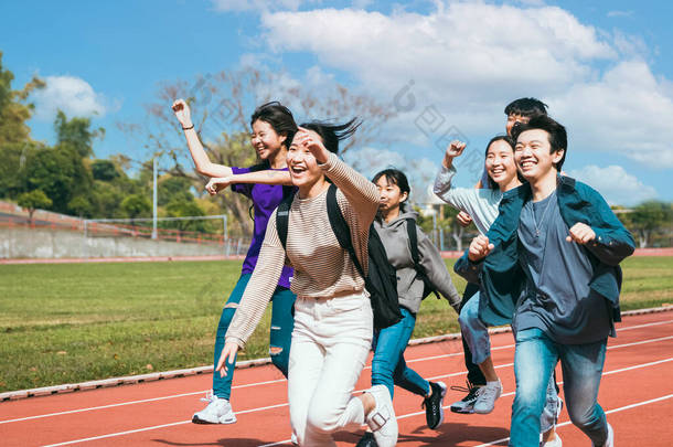  快乐的年轻团组学生在校园里奔跑
