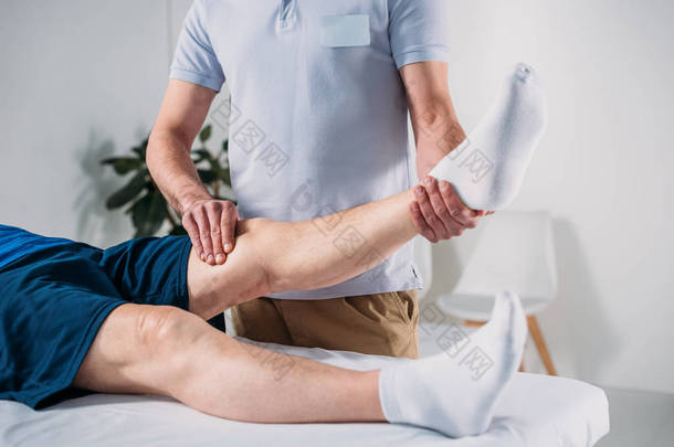 理疗师按摩桌上按摩老人腿的裁剪镜头老人健康
