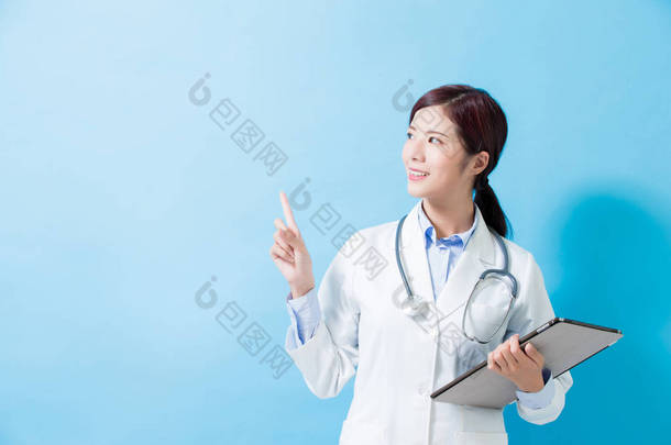 妇女医生显示的东西, 并采取平板电脑上的蓝色背景