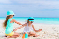 孩子们在沙滩上互相应用防晒霜。保护免受紫外线辐射的概念