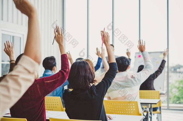 在会议室研讨会上，商界人士举手<strong>表示</strong>同意发言者的意见。