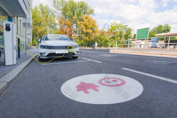 现代电动汽车在街上车站插上充电的插头.新能源车辆、环保汽车替代能源