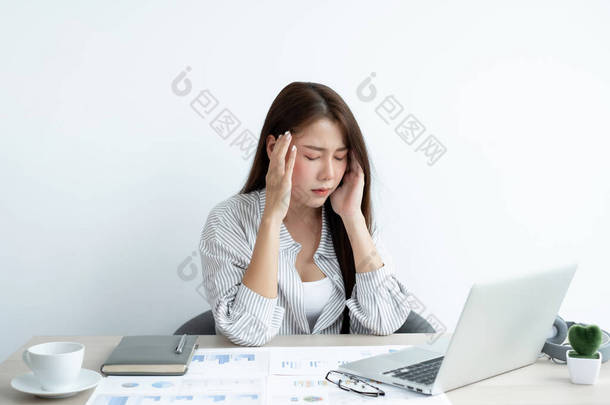 工作的亚洲<strong>妇女</strong>在办公室工作时感到压力大、工作累、因努力工作而头疼.