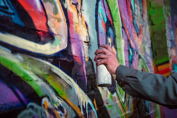 街头画家的裁剪视图夜间墙上涂有气溶胶颜料涂鸦