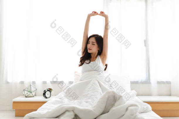 早上醒来后，女人伸展快乐和放松 
