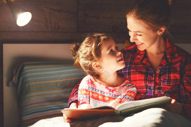 母亲和孩子睡觉前在床上看书