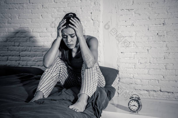 年轻漂亮的西班牙裔妇女在家里的卧室躺在床上深夜试图入睡失眠睡眠障碍或害怕恶梦看悲伤担心心理健康概念