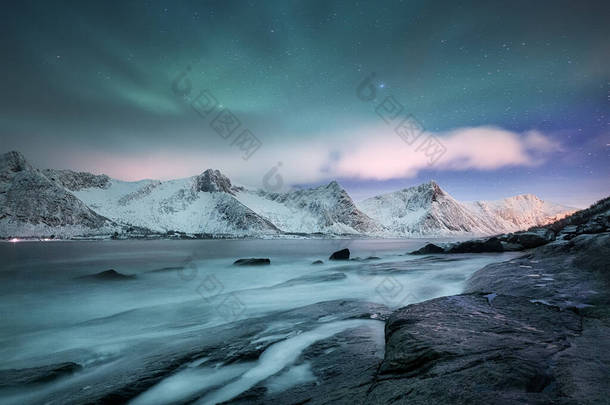 挪威Lofoten岛上的Aurora borealis 。高山上方的<strong>绿色</strong>北极光。带着极光的冬夜风景.挪威的自然背景.