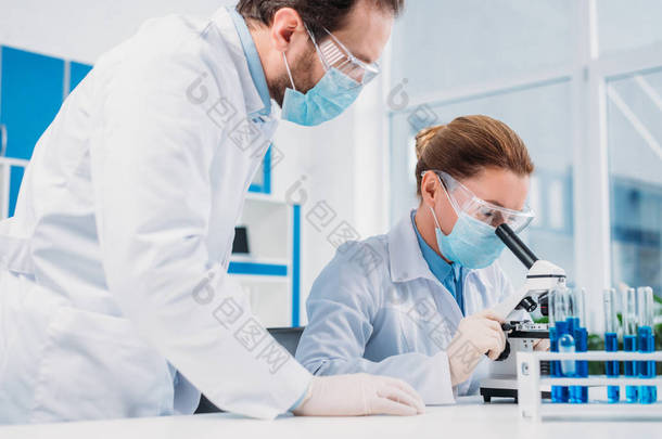 研究人员在白色大衣和医疗<strong>口罩</strong>一起使用试剂在实验室