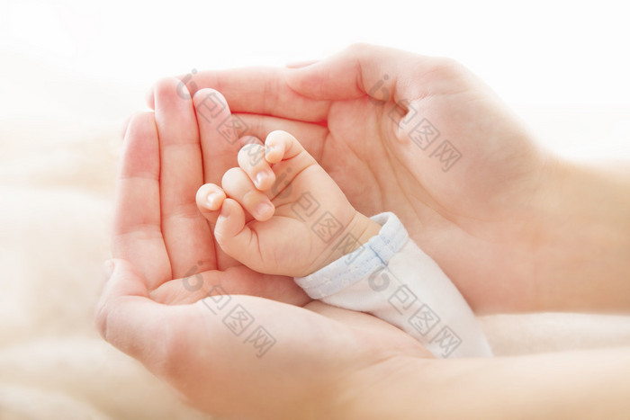 刚出生的婴儿手在母亲的手中新出生帮助协助