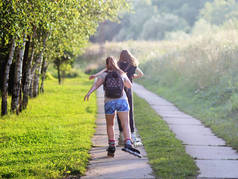 Yaslo, 波兰-2018年7月9日: 在阳光照射下, 两个女孩在绿叶间打滚。健康的生活方式和关爱的身影。体重减轻额外的公斤。晨跑.