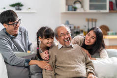 快乐的多代亚洲家庭的集体画像，坐在客厅的沙发上，面带微笑。Muti氏族家庭幸福概念.