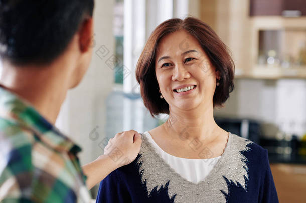 快乐而漂亮的<strong>中年</strong>妇女听到儿子谈论他的事业成功