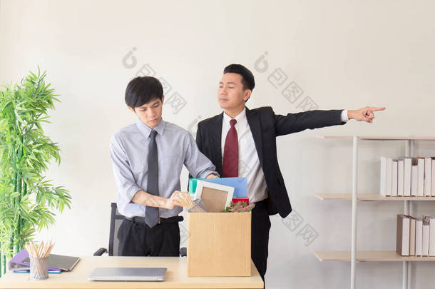 一位亚洲员工被解雇了，当时他正把自己的<strong>个人</strong>物品装在纸盒里，旁边站着一位经理.