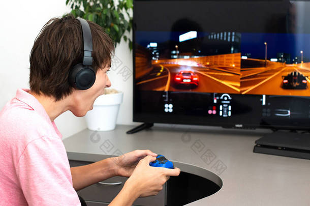 青少年男孩在网上玩一个带耳机和操纵杆的电脑游戏，游戏主机.