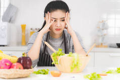 年轻妇女或家庭主妇对烹调感到厌烦，烹调包括各种水果和蔬菜供家庭食用.