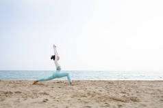 巴塞罗那，一个阳光灿烂的日子，适合女孩在海边沙滩上做瑜伽