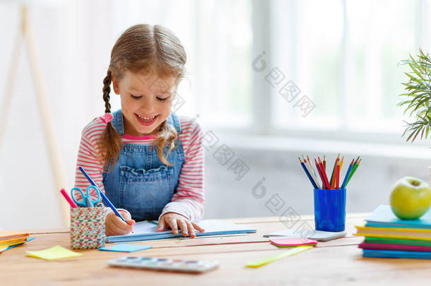 在家里做作业、写作和读书的小女孩
